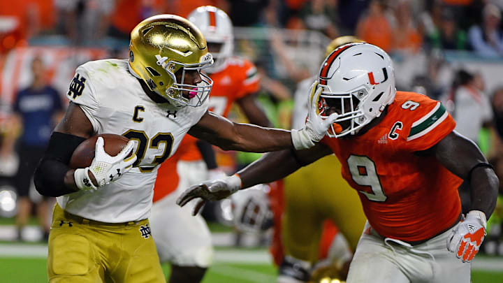 Nov 11, 2017; Miami Gardens, FL, USA; Notre Dame Fighting Irish running back Josh Adams (33) stiff arms Miami Hurricanes defensive lineman Chad Thomas (9) during the first half at Hard Rock Stadium. Nov 11, 2017; Miami Gardens, FL, USA; Notre Dame Fighting Irish running back Josh Adams (33) stiff arms Miami Hurricanes defensive lineman Chad Thomas (9) during the first half at Hard Rock Stadium.