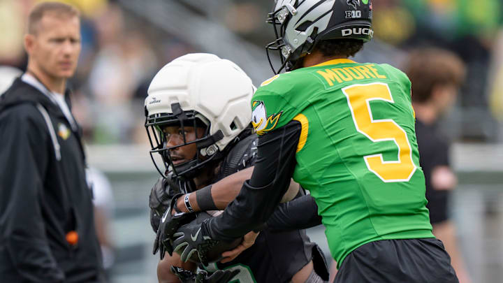 Combat Ducks quarterback Dante Moore hands off the ball to running back Noah Whittington as the Fighting Ducks face off against Mighty Oregon in the Oregon Ducks spring game on April 26, 2025, at Autzen Stadium in Eugene.