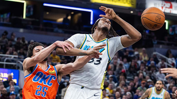 Dec 26, 2024; Indianapolis, Indiana, USA; Indiana Pacers center Myles Turner (33) and Oklahoma City Thunder guard Ajay Mitchell (25) fight for the ball in the first half at Gainbridge Fieldhouse. Mandatory Credit: Trevor Ruszkowski-Imagn Images