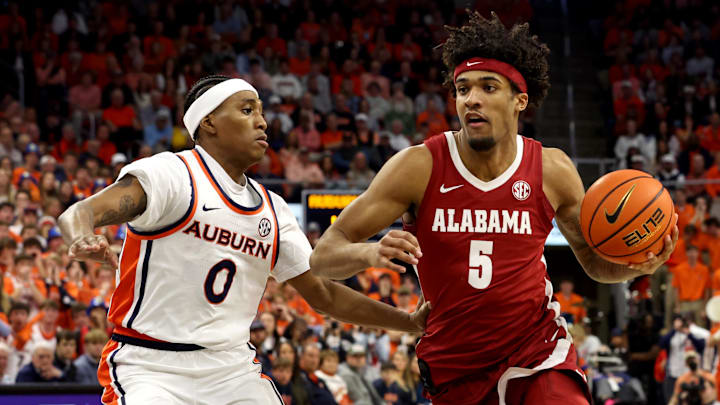 Feb 7, 2026; Auburn, Alabama, USA;  Alabama Crimson Tide forward Amari Allen (5) runs a play as Auburn Tigers guard Tahaad Pettiford (0) defends during the first half at Neville Arena. Mandatory Credit: John Reed-Imagn Images
