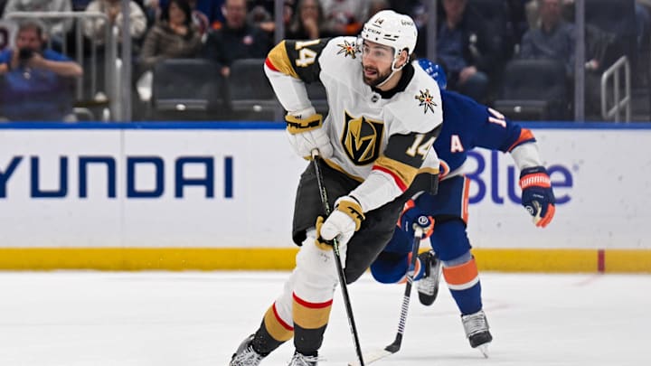 Feb 4, 2025; Elmont, New York, USA;  Vegas Golden Knights defenseman Nicolas Hague (14) skates with the puck against the New York Islanders during the third period at UBS Arena. Mandatory Credit: Dennis Schneidler-Imagn Images