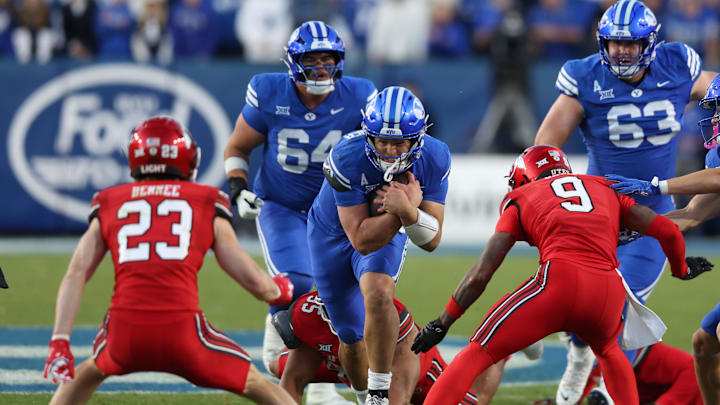 BYU Cougars quarterback Bear Bachmeier (middle) runs against Utah Utes safety Jackson Bennee (23) and cornerback Elijah Davis (9) during the first quarter at LaVell Edwards Stadium.