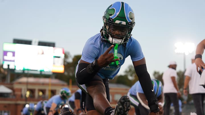 A Tulane Green Wave players stretches for a game against the Charlotte 49ers. A Tulane Green Wave players stretches for a game against the Charlotte 49ers.