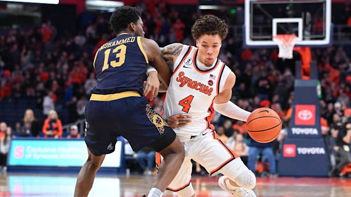 Jan 31, 2026; Syracuse, New York, USA; Syracuse Orange guard Nate Kingz (4) tries to move the ball past Notre Dame Fighting Irish guard Sir Mohammed (13) in the second half at the JMA Wireless Dome. Mandatory Credit: Mark Konezny-Imagn Images