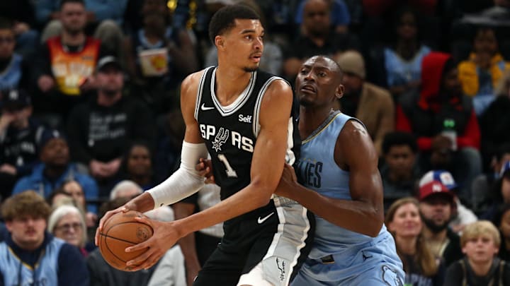 Jan 2, 2024; Memphis, Tennessee, USA; San Antonio Spurs center Victor Wembanyama (1) handles the ball as Memphis Grizzlies center Bismack Biyombo (18) defends during the first half at FedEx Forum.