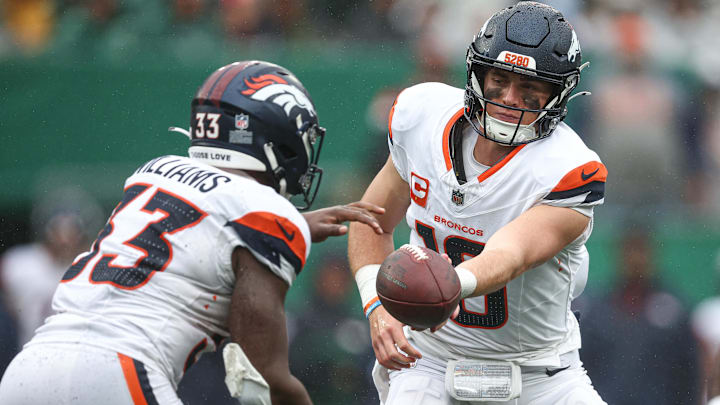 Sep 29, 2024; East Rutherford, New Jersey, USA; Denver Broncos quarterback Bo Nix (10) hands off to running back Javonte Williams (33) during the second half against the New York Jets at MetLife Stadium. 