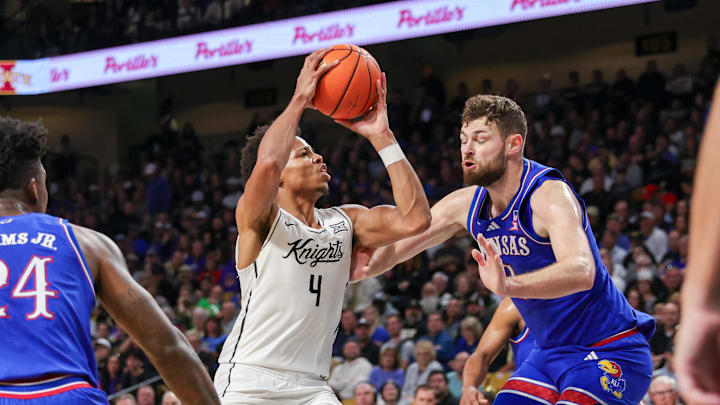 Jan 5, 2025; Orlando, Florida, USA; UCF Knights guard Keyshawn Hall (4) goes to the basket against Kansas Jayhawks center Hunter Dickinson (1) during the first half at Addition Financial Arena. Mandatory Credit: Mike Watters-Imagn Images