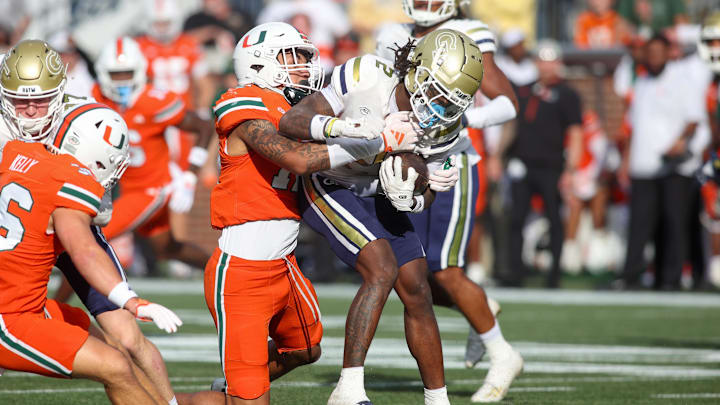 Nov 9, 2024; Atlanta, Georgia, USA; Miami Hurricanes defensive lineman Marquise Lightfoot (12) tackles Georgia Tech Yellow Jackets wide receiver Eric Singleton Jr. (2) in the fourth quarter at Bobby Dodd Stadium at Hyundai Field. Mandatory Credit: Brett Davis-Imagn Images Nov 9, 2024; Atlanta, Georgia, USA; Miami Hurricanes defensive lineman Marquise Lightfoot (12) tackles Georgia Tech Yellow Jackets wide receiver Eric Singleton Jr. (2) in the fourth quarter at Bobby Dodd Stadium at Hyundai Field. Mandatory Credit: Brett Davis-Imagn Images