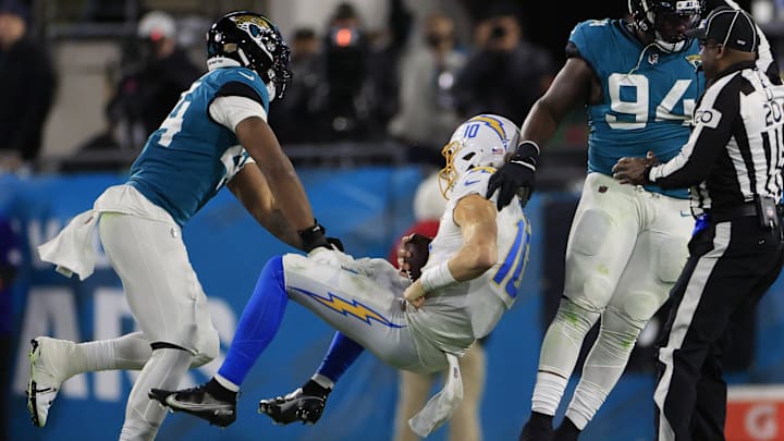 Los Angeles Chargers quarterback Justin Herbert (10) is shoved by Jacksonville Jaguars linebacker Travon Walker (44) during the fourth quarter of an NFL first round playoff football matchup Saturday, Jan. 14, 2023 at TIAA Bank Field in Jacksonville, Fla. A 15-yard penalty was called on the play. Jacksonville Jaguars edged the Los Angeles Chargers on a field goal 31-30. [Corey Perrine/Florida Times-Union]