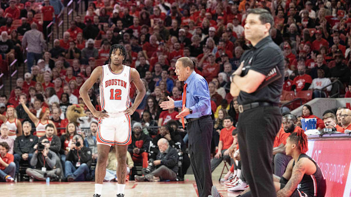 Jan 28, 2023; Houston, Texas, USA; Houston Cougars head coach Kelvin Sampson talks with Houston Cougars guard Tramon Mark (12) while Cincinnati Bearcats head coach Wes Miller watches play in the first half at Fertitta Center. Mandatory Credit: Thomas Shea-Imagn Images