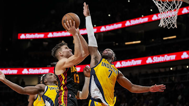 Jan 12, 2024; Atlanta, Georgia, USA; Atlanta Hawks guard Bogdan Bogdanovic (13) shoots against Indiana Pacers guard Buddy Hield (7) during the second half at State Farm Arena. Mandatory Credit: Dale Zanine-Imagn Images