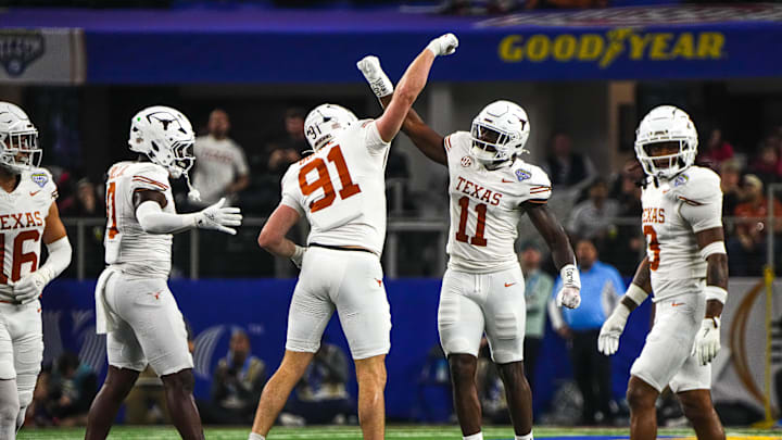 Texas Longhorns edge rushers Colin Simmons (11) and Ethan Burke (91) celebrate a sack during the College Football Playoff semifinal game against Ohio State in the Cotton Bowl at AT&T Stadium on Friday, Jan. 10, 2024 in Arlington, Texas.