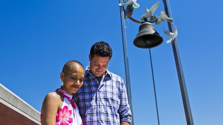 May 8,2017; Memphis, TN, USA; Sauphia and Dan Lanning bow their heads as Braxton Brady (not pictured), director of player relations for the University of Memphis, prays for them at the West Cancer Center on Monday. Lanning, the inside linebackers coach for the University of Memphis, has stood by his wife as she's fought osteosarcoma, a rare, aggressive form of cancer, for nearly a year. On Monday, she had a bell-ringing ceremony to signify the end of her active treatment. Mandatory Credit: