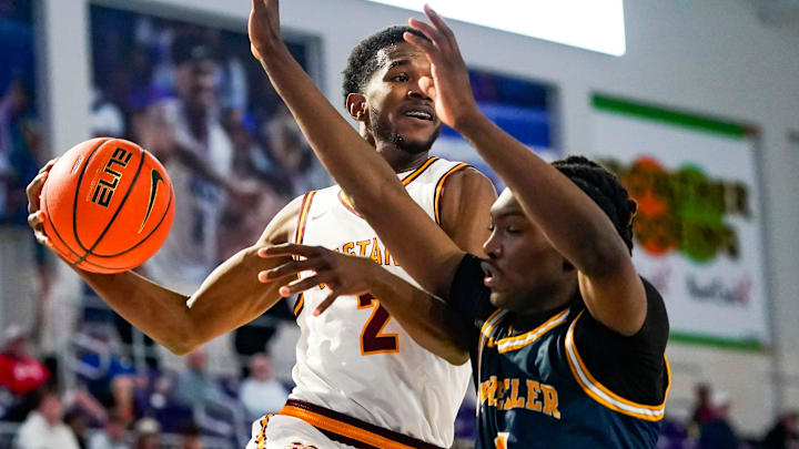 Bishop McNamara Mustangs guard Prince-Alexander Moody (2) looks to pass as Wheeler Wildcats forward Jaron Saulsberry (1) guards him during the first quarter of a City of Palms Classic first round game at Suncoast Credit Union Arena in Fort Myers, Fla., on Friday, Dec. 19, 2025.