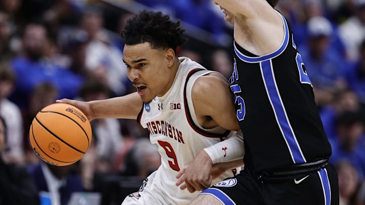 Mar 22, 2025; Denver, CO, USA; Wisconsin Badgers guard John Tonje (9) dribbles the ball past Brigham Young Cougars guard Dawson Baker (25) during the first half in the second round of the NCAA Tournament  at Ball Arena. 