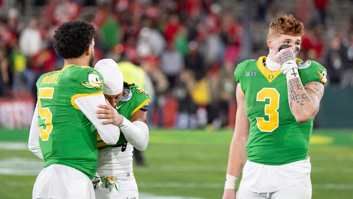 Oregon quarterback Dante Moore, left, defensive back Brandon Johnson and tight end Terrance Ferguson walk off the field as the Oregon Ducks face the Ohio State Buckeyes Wednesday, Jan. 1, 2025, in the quarterfinal of the College Football Playoff at the Rose Bowl in Pasadena, Calif.