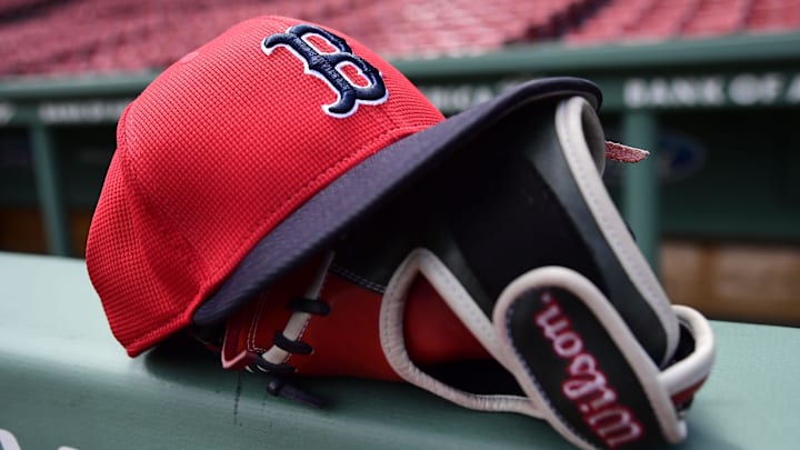 May 18, 2025; Boston, Massachusetts, USA;  A Boston Red Sox hat and glove rests on the railing by the dugout prior to a game against the Atlanta Braves at Fenway Park. Mandatory Credit: Bob DeChiara-Imagn Images