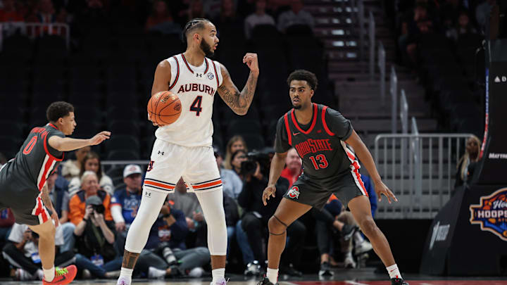 Dec 14, 2024; Atlanta, Georgia, USA; Auburn Tigers forward Johni Broome (4) signals for team against Ohio State Buckeyes forward Sean Stewart (13) during the second half at State Farm Arena. Mandatory Credit: Jordan Godfree-Imagn Images