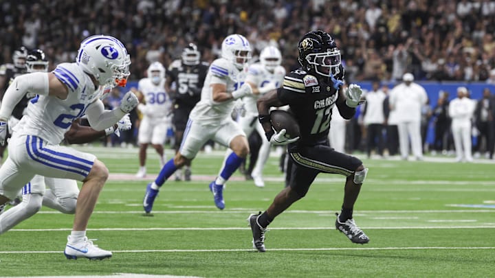 Dec 28, 2024; San Antonio, TX, USA; Colorado Buffaloes wide receiver Travis Hunter (12) runs with the ball and scores a touchdown during the third quarter against the Brigham Young Cougars at Alamodome. Mandatory Credit: Troy Taormina-Imagn Images