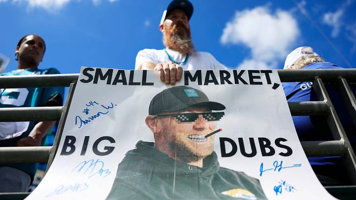Mike Norvelle looks on with his poster of Jacksonville Jaguars head coach Liam Coen before an NFL football matchup at EverBank Stadium on Sunday, Sept. 13, 2026, in Jacksonville, Fla. The Jaguars defeated the Browns 34-10. [Corey Perrine/Florida Times-Union]