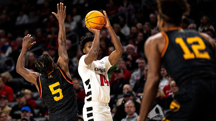 Cincinnati Bearcats forward Tyler Betsey (14) hits a 3-point basket over Grambling State Tigers guard Chilaydrien Newton (5) in the first half of the NCAA basketball game at Fifth Third Arena in Cincinnati on Sunday, Dec. 22, 2024.