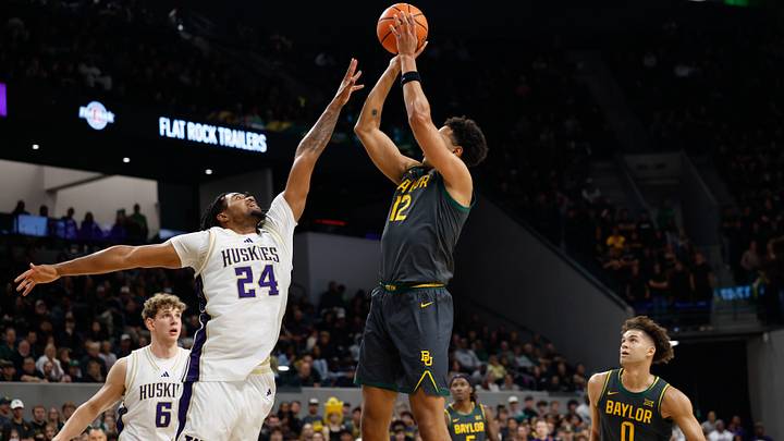 Baylor guard Michael Rataj (12) scores a basket against the UW's Lathan Sommerville (24) in 2025. Baylor guard Michael Rataj (12) scores a basket against the UW's Lathan Sommerville (24) in 2025.