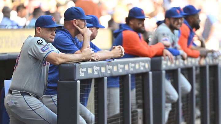 Sep 29, 2024; Milwaukee, Wisconsin, USA; New York Mets manager Carlos Mendoza (64) looks on from the dug out against the Milwaukee Brewers in the first inning at American Family Field. Mandatory Credit: Michael McLoone-Imagn Images