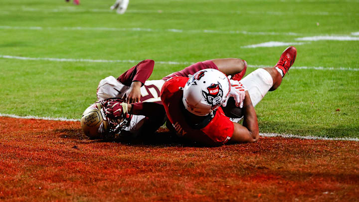 Nov 21, 2025; Raleigh, North Carolina, USA;  NC State Wolfpack tight end Justin Joly (7) makes a touchdown to win the game past Florida State Seminoles defensive back Shamar Arnoux (15) during the second half of the game at Carter-Finley Stadium. Mandatory Credit: Jaylynn Nash-Imagn Images