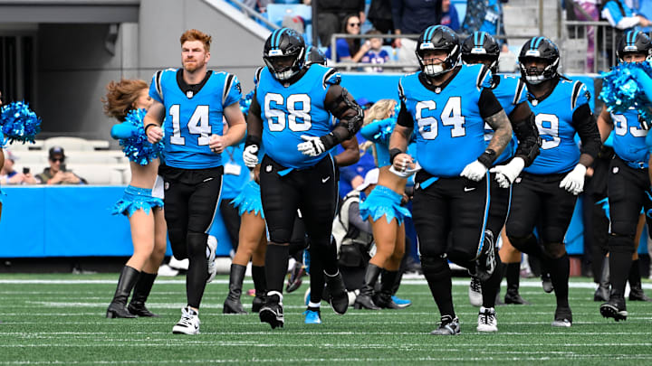 Oct 26, 2025; Charlotte, North Carolina, USA; Carolina Panthers quarterback Andy Dalton (14) runs on to the field with guard Damien Lewis (68) and center Cade Mays (64) before the game at Bank of America Stadium.