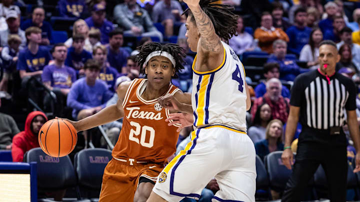Feb 1, 2025; Baton Rouge, Louisiana, USA;  Texas Longhorns guard Tre Johnson (20) dribbles against LSU Tigers guard Dji Bailey (4) during the second half at Pete Maravich Assembly Center. Mandatory Credit: Stephen Lew-Imagn Images