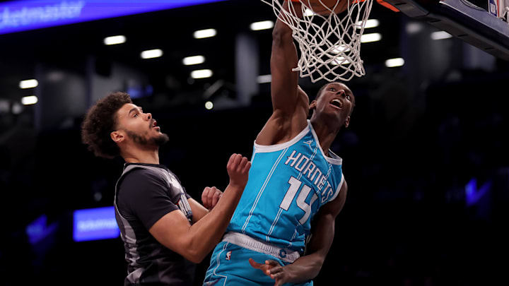 Feb 10, 2025; Brooklyn, New York, USA; Charlotte Hornets forward Moussa Diabate (14) dunks against Brooklyn Nets forward Cameron Johnson (2) during the first quarter at Barclays Center. Mandatory Credit: Brad Penner-Imagn Images