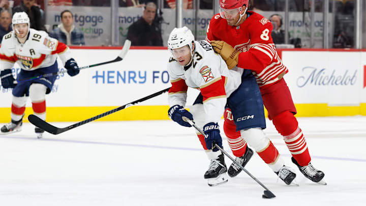 Mar 6, 2026; Detroit, Michigan, USA;  Florida Panthers center Carter Verhaeghe (23) skates with the puck defended by Detroit Red Wings defenseman Ben Chiarot (8) in the third period at Little Caesars Arena. Mandatory Credit: Rick Osentoski-Imagn Images