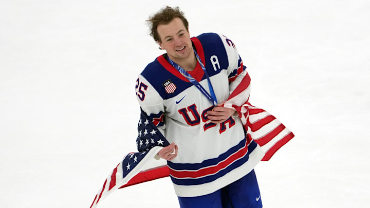 Feb 22, 2026; Milan, Italy; Charlie McAvoy of the United States (center) celebrates after winning the men's ice hockey gold medal game during the Milano Cortina 2026 Olympic Winter Games at Milano Santagiulia Ice Hockey Arena. Mandatory Credit: James Lang-Imagn Images