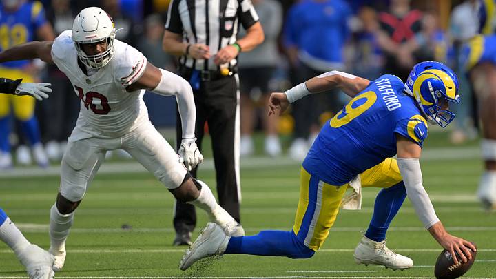 Oct 18, 2026; Inglewood, California, USA;  Los Angeles Rams quarterback Matthew Stafford (9) drops to the ground on pressure from Arizona Cardinals linebacker Josh Sweat (10) in the fourth quarter at SoFi Stadium.  Mandatory Credit: Jayne Kamin-Oncea-Imagn Images