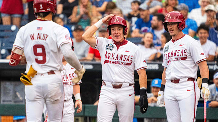 Jun 17, 2025; Omaha, Neb, USA; Arkansas Razorbacks left fielder Charles Davalan (24) and right fielder Logan Maxwell (22) look on as shortstop Wehiwa Aloy (9) heads home after a two-run home run against the UCLA Bruins during the first inning at Charles Schwab Field. Mandatory Credit: Dylan Widger-Imagn Images
