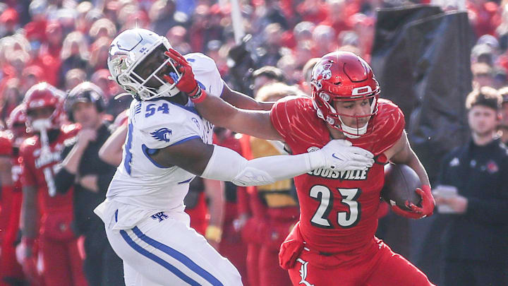 Kentucky Wildcats linebacker D'Eryk Jackson (54) tries to stop Louisville Cardinals running back Isaac Guerendo (23) in the first half of the 2023 Governor's Cup game in Louisville. Nov. 24, 2023