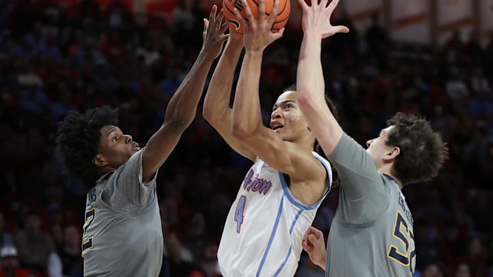 Jan 13, 2026; Houston, Texas, USA; Houston Cougars guard Kingston Flemings (4) splits the defense West Virginia Mountaineers guard Amir Jenkins (2) and guard Treysen Eaglestaff (52) in the first half at Fertitta Center. Mandatory Credit: Thomas Shea-Imagn Images Jan 13, 2026; Houston, Texas, USA; Houston Cougars guard Kingston Flemings (4) splits the defense West Virginia Mountaineers guard Amir Jenkins (2) and guard Treysen Eaglestaff (52) in the first half at Fertitta Center. Mandatory Credit: Thomas Shea-Imagn Images