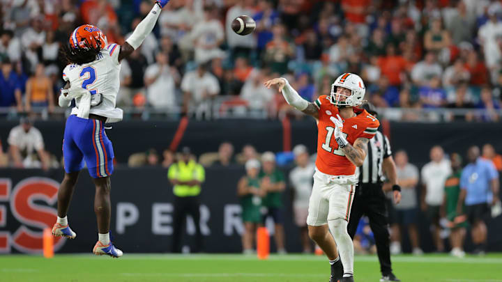 Sep 20, 2025; Miami Gardens, Florida, USA; Miami Hurricanes quarterback Carson Beck (11) passes the football as Florida Gators defensive back Lagonza Hayward (2) attempts a block during the fourth quarter at Hard Rock Stadium. Mandatory Credit: Sam Navarro-Imagn Images
