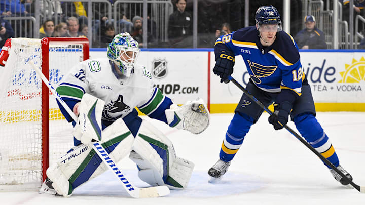 Jan 27, 2025; St. Louis, Missouri, USA;  Vancouver Canucks goaltender Kevin Lankinen (32) defends the net against St. Louis Blues center Radek Faksa (12) during the second period at Enterprise Center. Mandatory Credit: Jeff Curry-Imagn Images