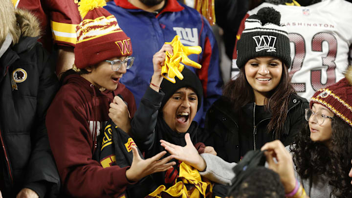 Dec 29, 2024; Landover, Maryland, USA; Washington Commanders fans cheer from the stands after Commanders cornerback Benjamin St-Juste (25) give fans gloves after the game against the Atlanta Falcons at Northwest Stadium. Mandatory Credit: Amber Searls-Imagn Images
