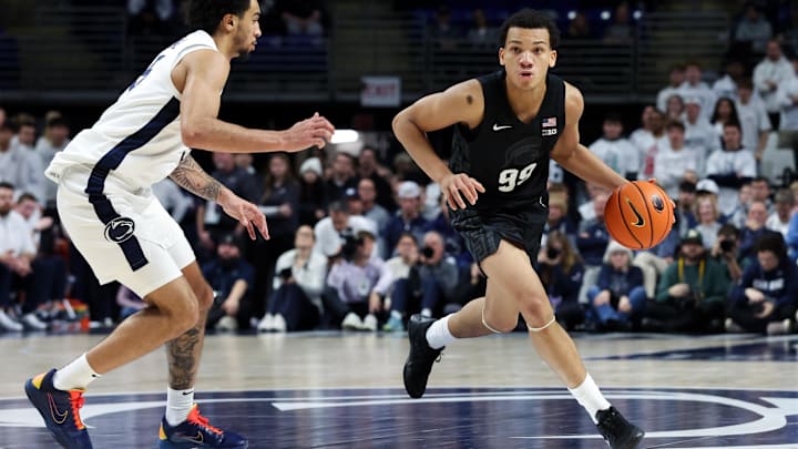 Dec 13, 2025; University Park, Pennsylvania, USA; Michigan State Spartans guard Divine Ugochukwu (99) dribbles the ball up the court as Penn State Nittany Lions guard Freddie Dilione V (5) defends during the second half at Bryce Jordan Center. Mandatory Credit: Matthew O'Haren-Imagn Images