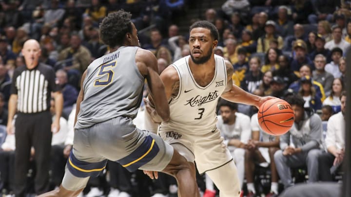 Mar 8, 2025; Morgantown, West Virginia, USA; UCF Knights guard Darius Johnson (3) dribbles against West Virginia Mountaineers guard Toby Okani (5) during the second half at WVU Coliseum. Mandatory Credit: Ben Queen-Imagn Images