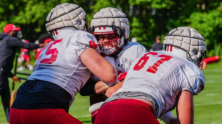 Offensive lineman Joe Brunner, center, takes on Kevin Heywood (55) and JP Benzschawel (67) during football practice Wednesday, August 14, 2024 in Madison, Wisconsin.