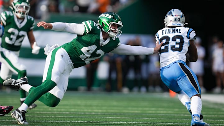 New York Jets long snapper Thomas Hennessy (42) attempts a tackle as Carolina Panthers running back Trevor Etienne (23) runs the ball New York Jets long snapper Thomas Hennessy (42) attempts a tackle as Carolina Panthers running back Trevor Etienne (23) runs the ball