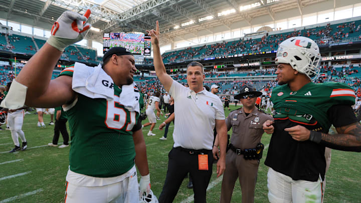 Nov 23, 2024; Miami Gardens, Florida, USA; Miami Hurricanes head coach Mario Cristobal celebrates with Miami Hurricanes offensive lineman Francis Mauigoa (61) and tight end Elijah Arroyo (8) after the game against the Wake Forest Demon Deacons at Hard Rock Stadium. Mandatory Credit: Sam Navarro-Imagn Images