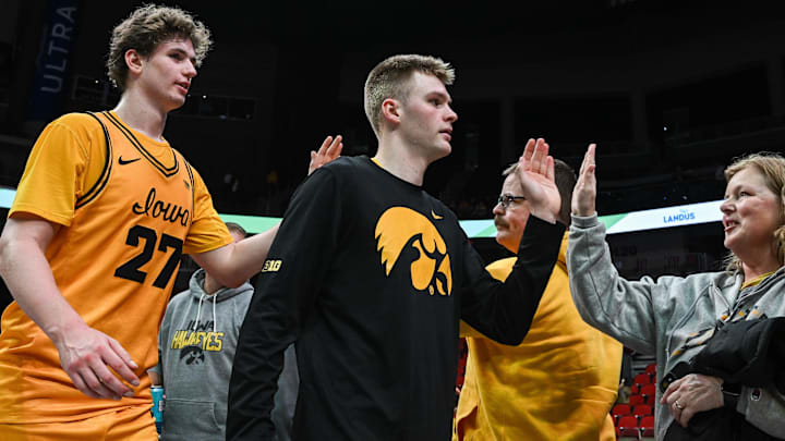 Iowa Hawkeyes guard Bennett Stirtz (14) and center Trevin Jirak (27) react with fans
