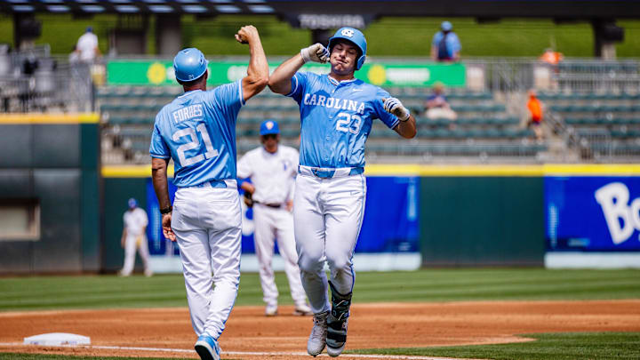 May 23, 2024; Charlotte, NC, USA; North Carolina Tar Heels designated hitter Alberto Osuna (23) celebrates a home run with head coach Scott Forbes in the first inning against the Pittsburgh Panthers during the ACC Baseball Tournament at Truist Field. Mandatory Credit: Scott Kinser-Imagn Images