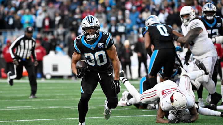 Dec 22, 2024; Charlotte, North Carolina, USA; Carolina Panthers running back Chuba Hubbard (30) breaks free for a touchdown to win the game in overtime as Arizona Cardinals cornerback Sean Murphy-Bunting (23) and safety Jalen Thompson (34) defend at Bank of America Stadium. Mandatory Credit: Bob Donnan-Imagn Images