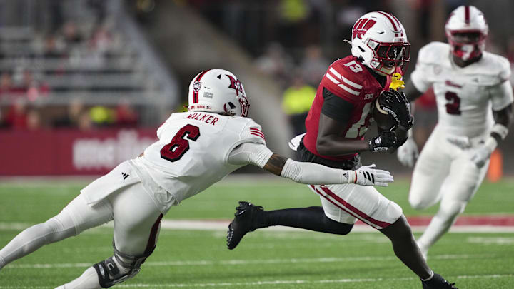 Aug 28, 2025; Madison, Wisconsin, USA;  Wisconsin Badgers wide receiver Eugene Hilton Jr. (13) rushes with the football against Miami (OH) RedHawks defensive back Adrian Walker Jr. (6) during the third quarter at Camp Randall Stadium. Mandatory Credit: Jeff Hanisch-Imagn Images