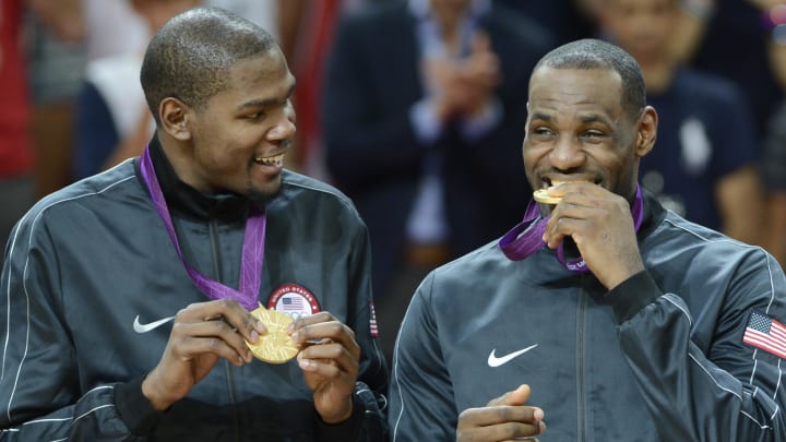 Aug 11, 2012; London, United Kingdom; USA forward Kevin Durant watches USA forward LeBron James bite the gold medal after winning the gold in the men's basketball final against Spain in the London 2012 Olympic Games at North Greenwich Arena. Mandatory Credit: Bob Donnan-USA TODAY Sports